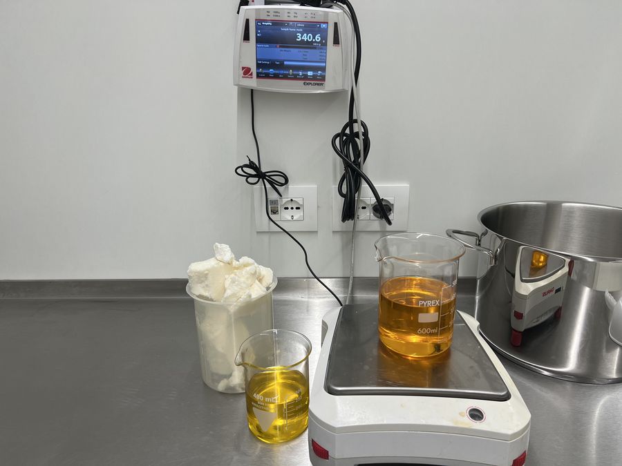 Oli vegetali e burro di karité pesati in laboratorio